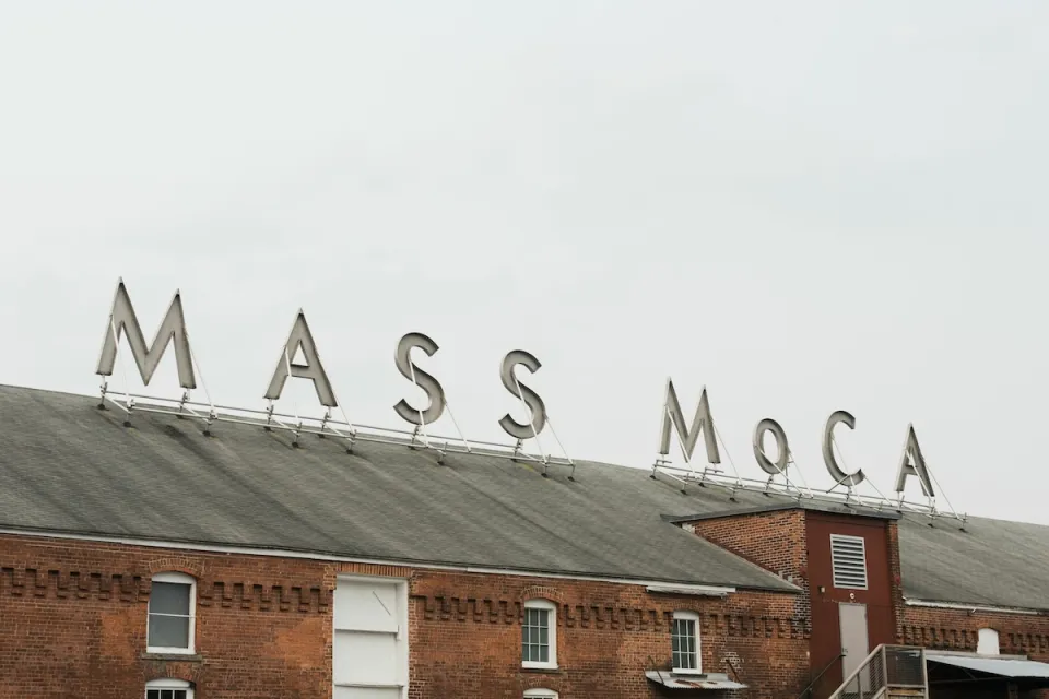 Sign for MASS MoCA on brick building.